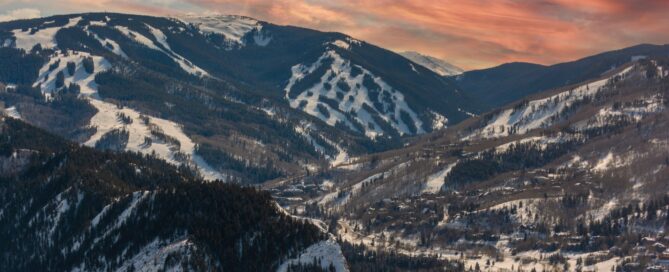 Snow-covered mountains of Beaver Creek, Colorado, featuring ski trails and a scenic sunset sky, highlighting the resort's winter sports appeal.