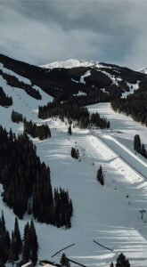 Snow-covered slopes at Copper Mountain with ski trails and evergreen trees, illustrating the ski resort's scenic landscape and accessibility for visitors.
