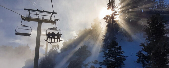 Ski lift ascending through snowy landscape with sunlight filtering through trees, showcasing Beaver Creek's winter sports environment.