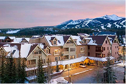 Ski resort accommodations at sunset with snow-covered mountains in the background, highlighting winter sports access in Colorado.