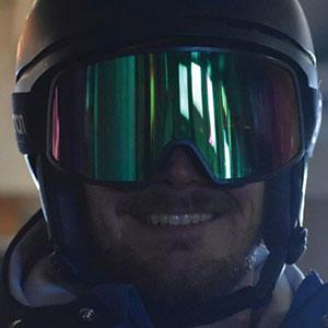 Smiling skier wearing a helmet and mirrored goggles, representing winter sports expertise at Charter Sports in Breckenridge.