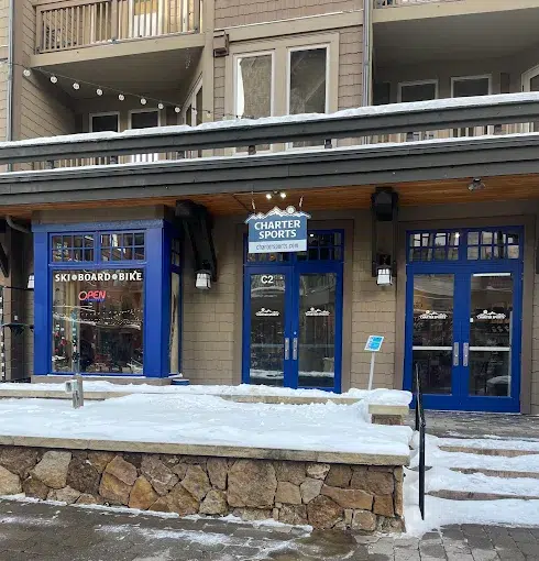 Charter Sports ski and snowboard rental shop entrance at Copper Mountain, featuring blue doors, signage, and snow-covered surroundings.