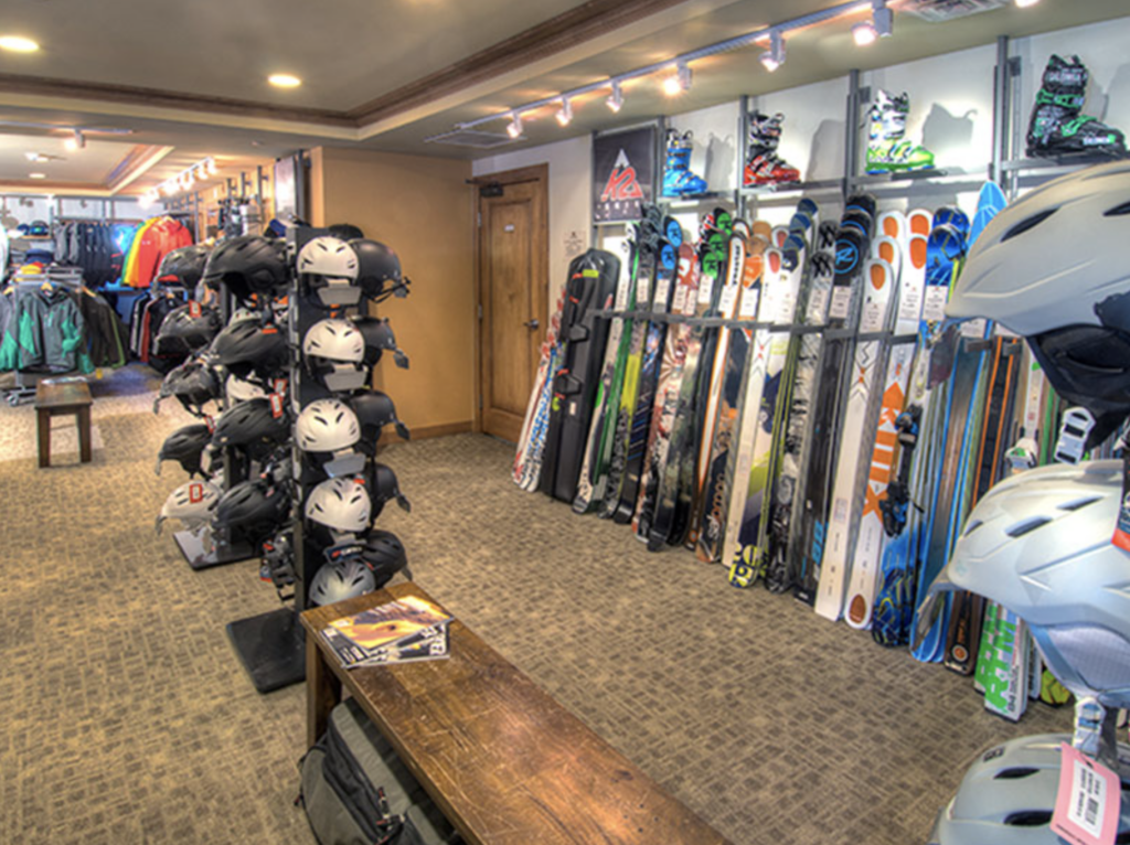 Ski rental shop interior featuring helmets, skis, and ski boots, showcasing Charter Sports' convenient slopeside rental options for skiers.