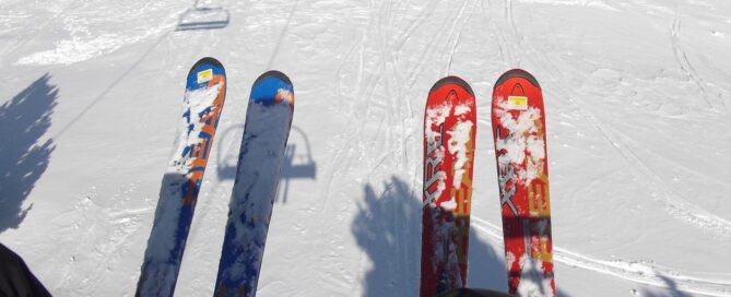 Skis resting on snow with a ski lift in the background, representing ski rental options at Copper Mountain.